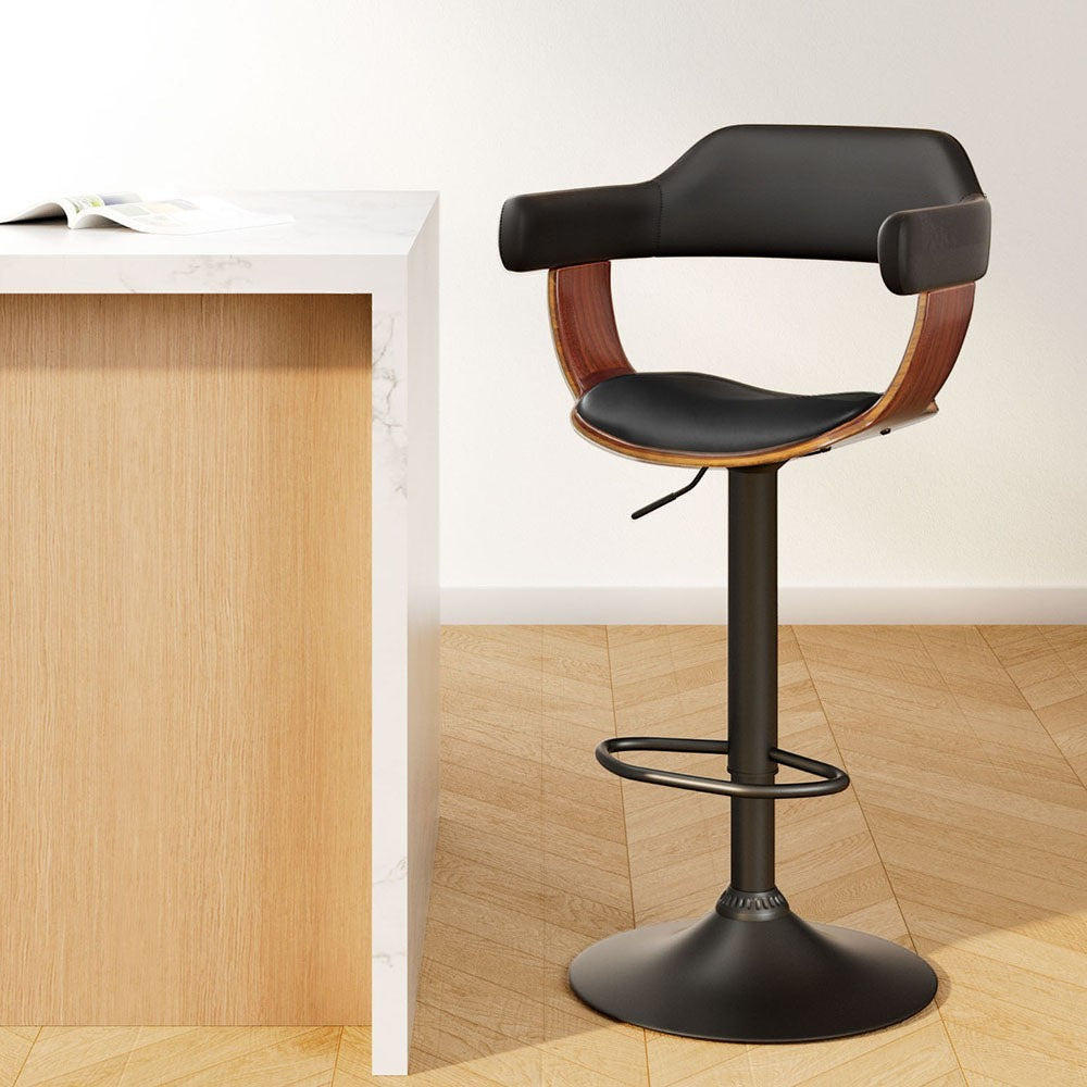 Dromana black faux leather swivel bar stool with armrests in a modern kitchen