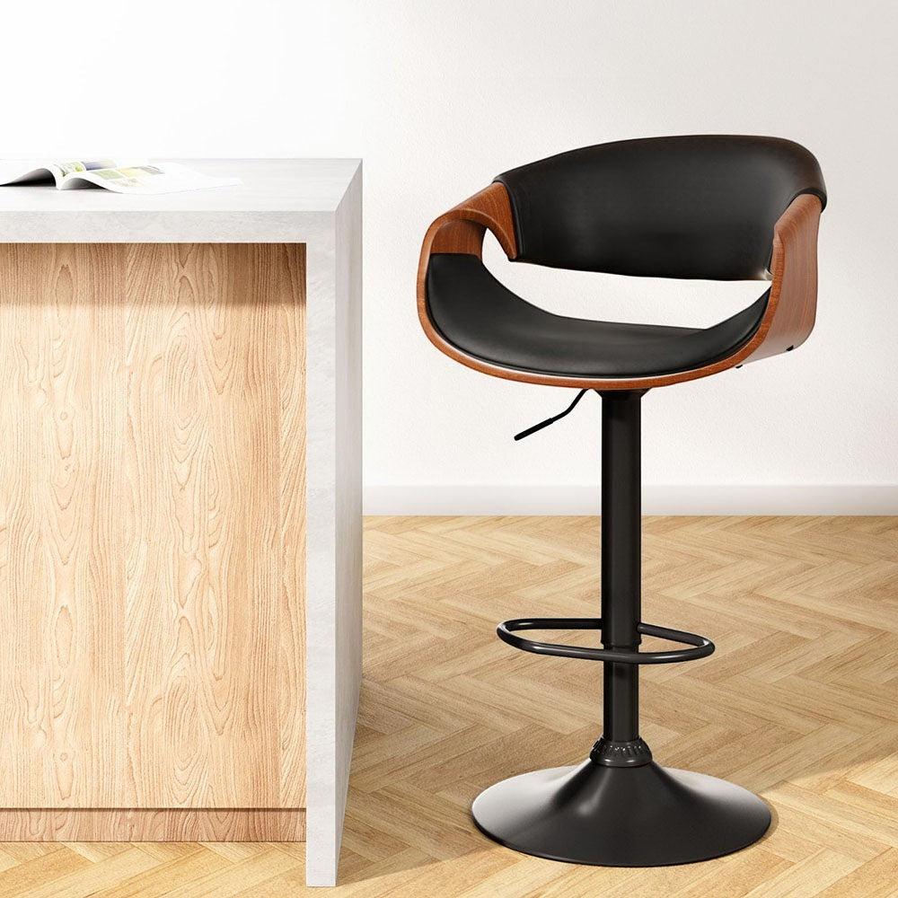 Tenby Point black gas lift swivel bar stool with curved backrest in a modern kitchen