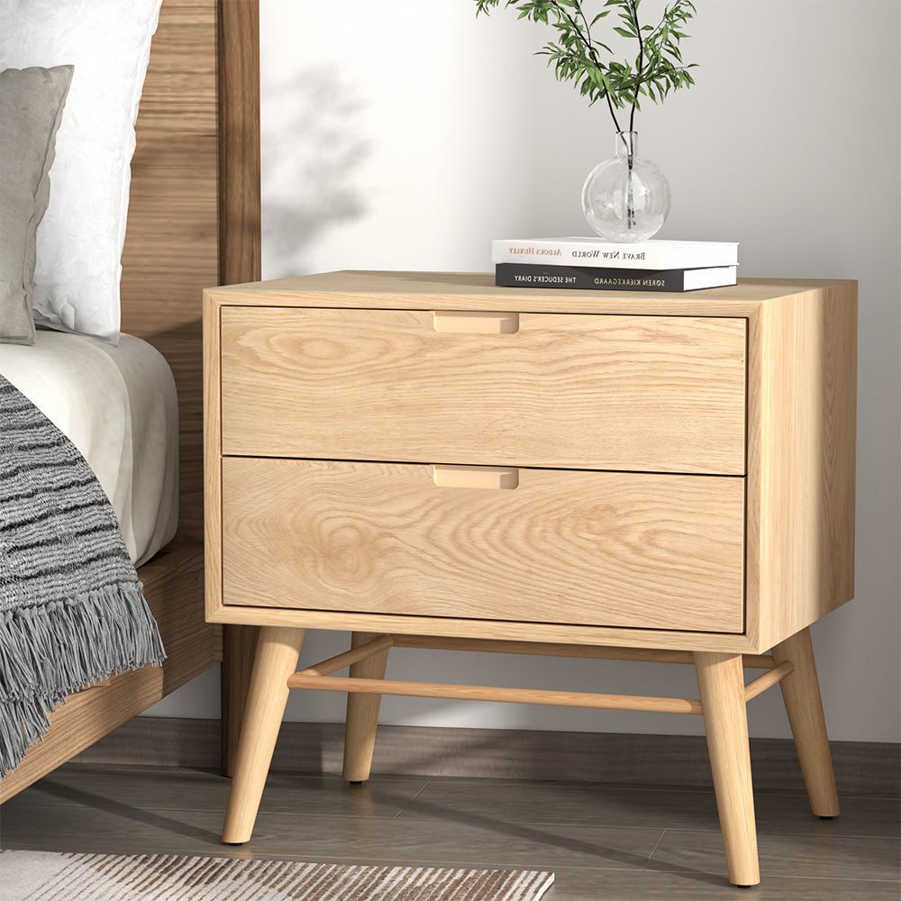 Federal pine two drawer bedside table with splayed ash wood legs in a rustic bedroom