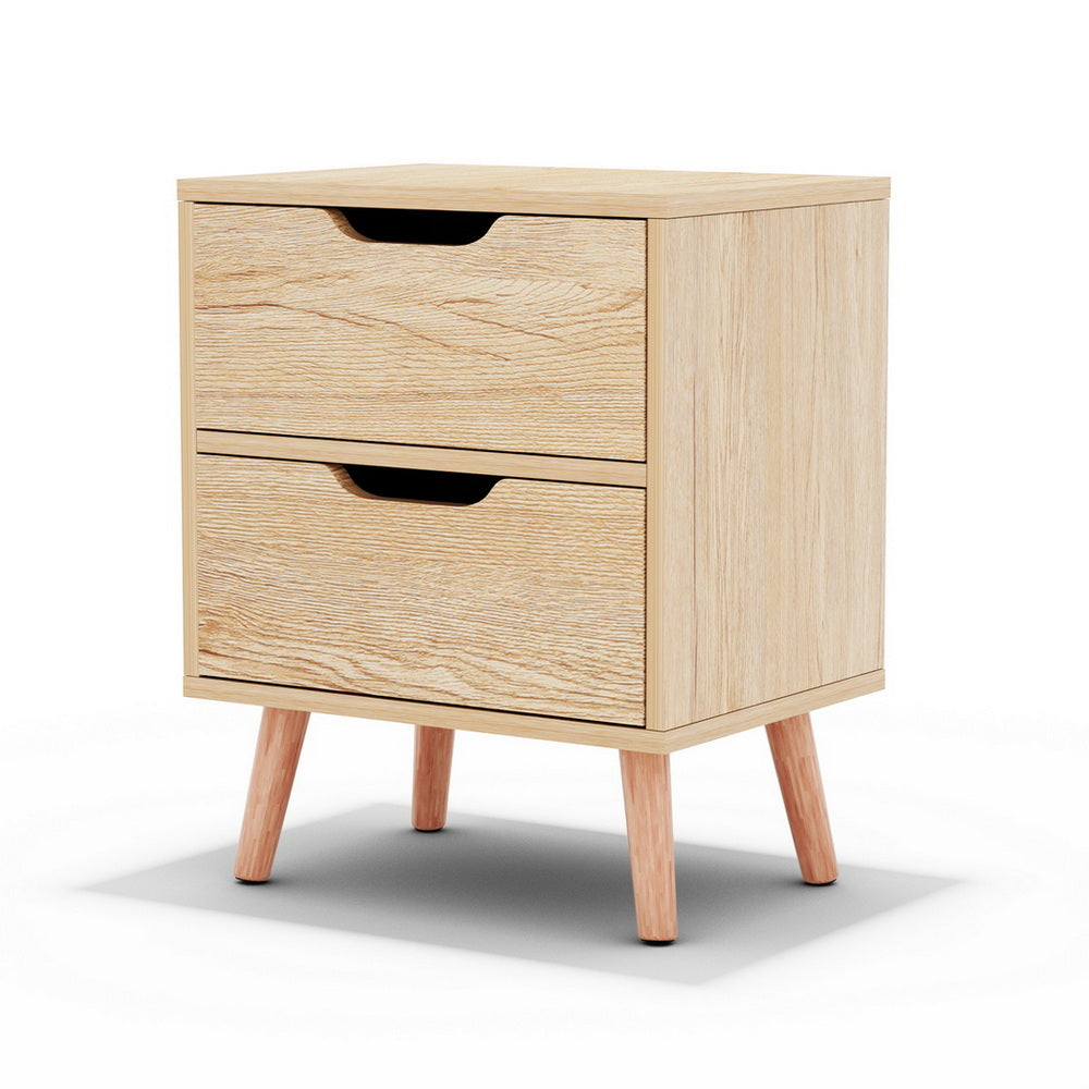 The Channon pine two drawer bedside table with splayed beech legs in a modern bedroom