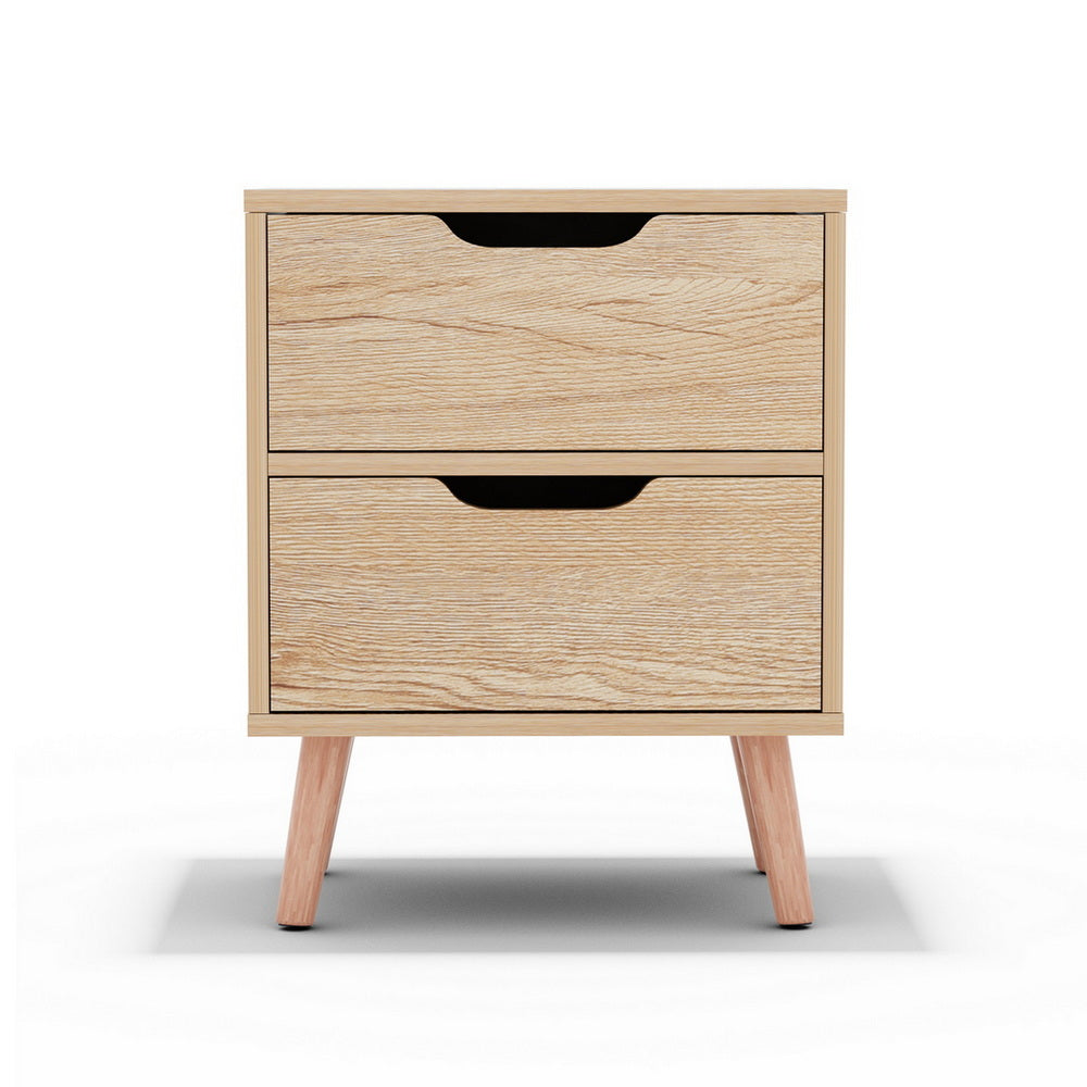 The Channon pine two drawer bedside table with splayed beech legs in a modern bedroom