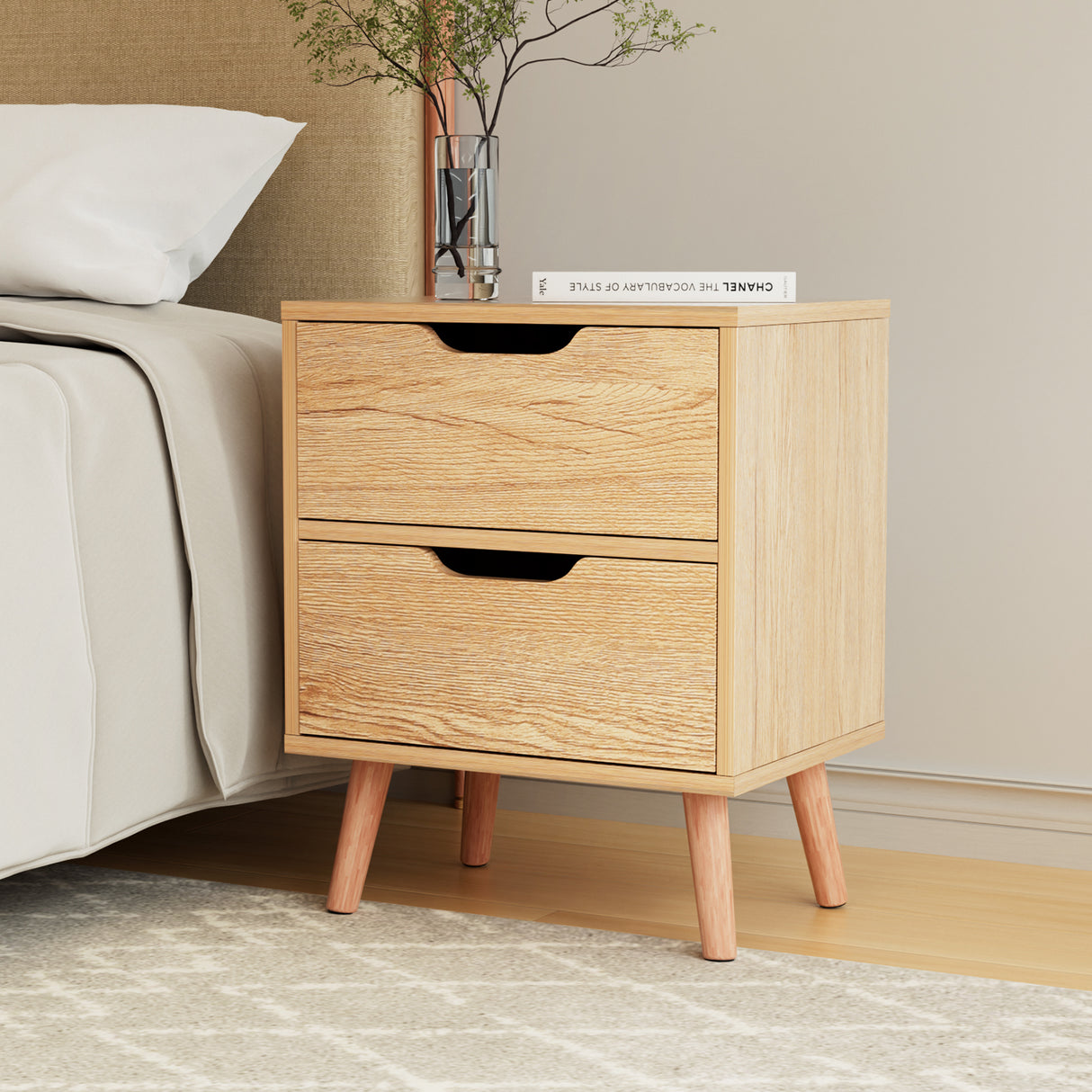The Channon pine two drawer bedside table with splayed beech legs in a modern bedroom