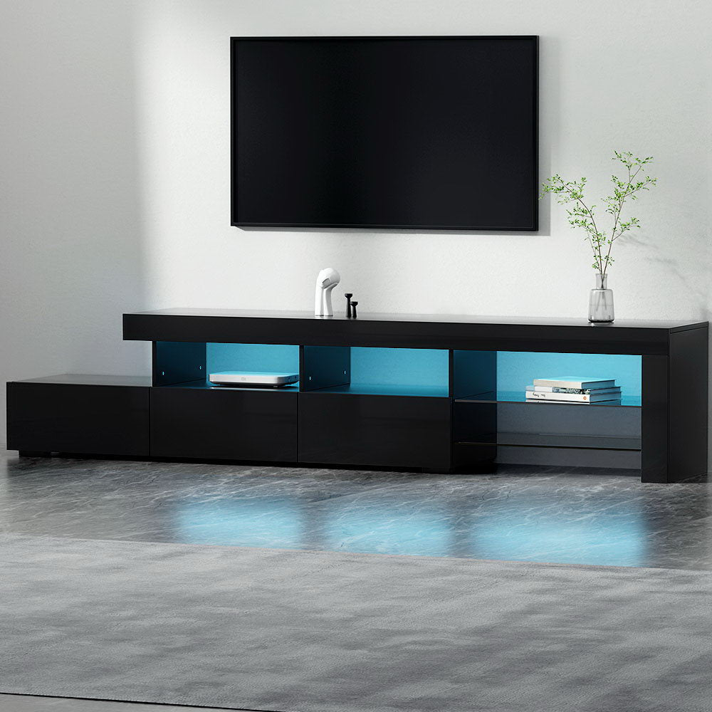 Penguin 215cm black LED entertainment unit with colour changing lighting and glass shelves in a modern living room