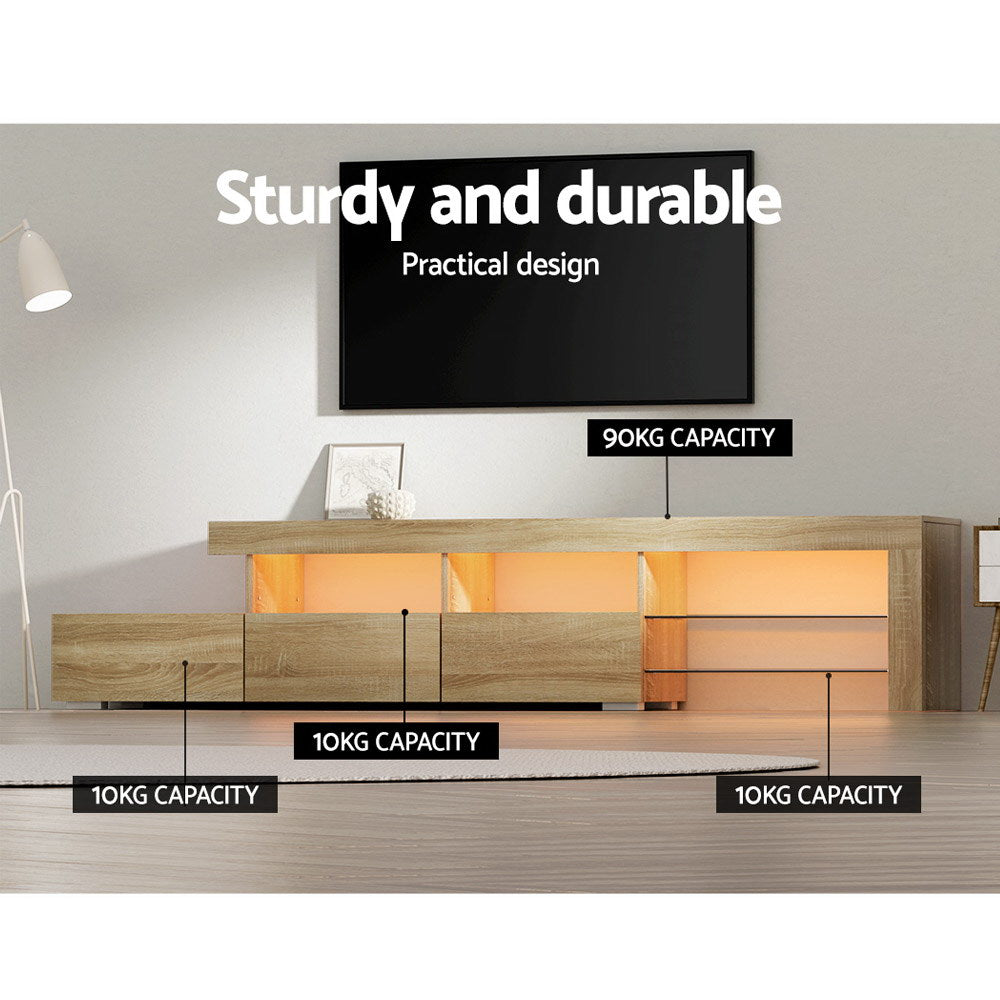 Penguin 215cm pine LED entertainment unit with colour changing lighting and glass shelves in a modern living room