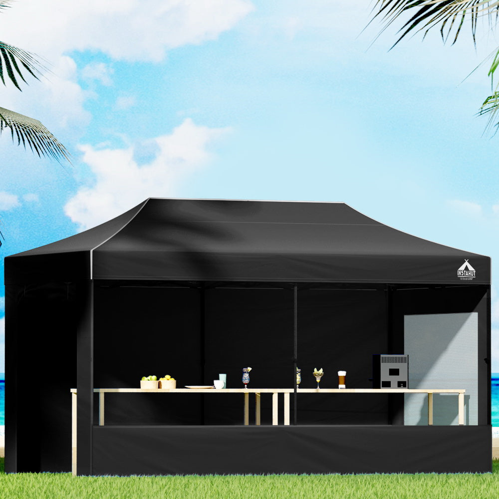 Black 3 x 6 m pop up gazebo erected outdoors with steel frame and long canopy
