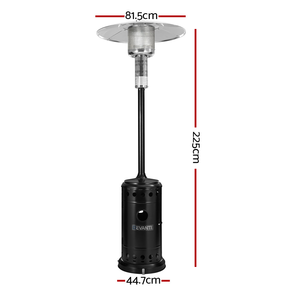 Tall gas patio heater warming an outdoor dining setting at night