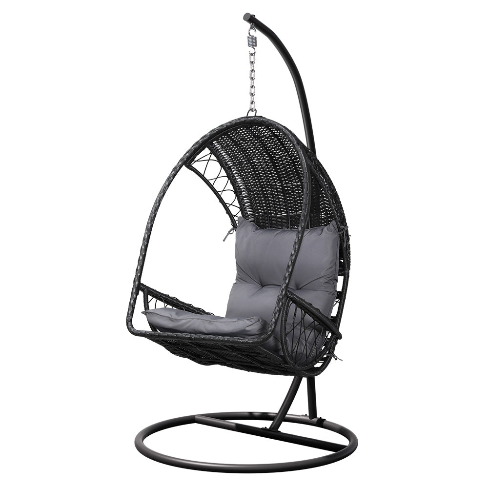 Gerroa black resin wicker hanging egg chair with stand on a patio