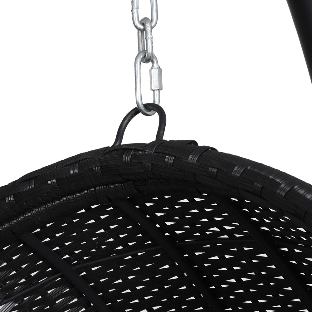 Gerroa black resin wicker hanging egg chair with stand on a patio