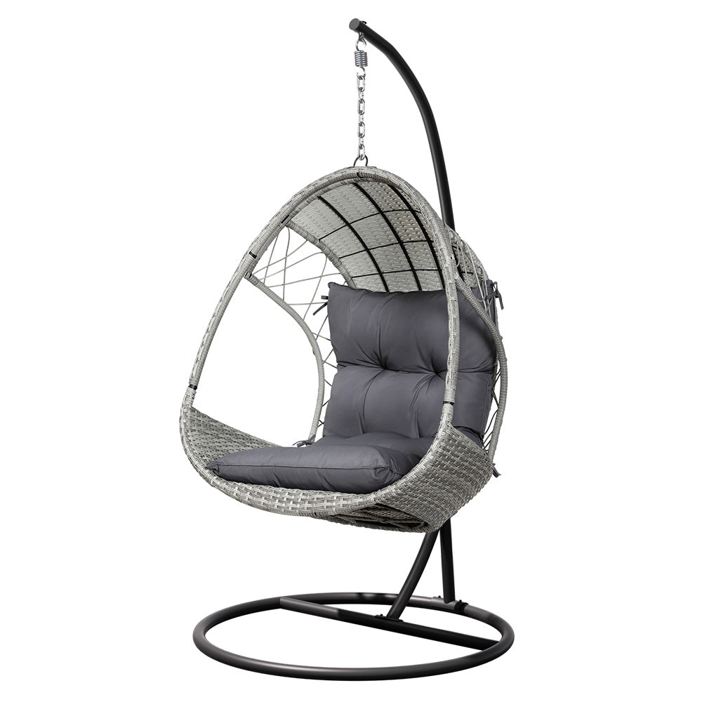 Gerroa light grey resin wicker hanging egg chair with stand on a patio