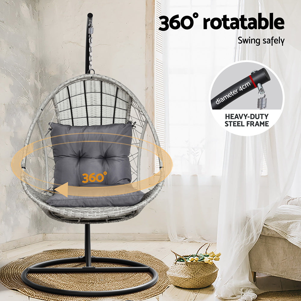 Gerroa light grey resin wicker hanging egg chair with stand on a patio