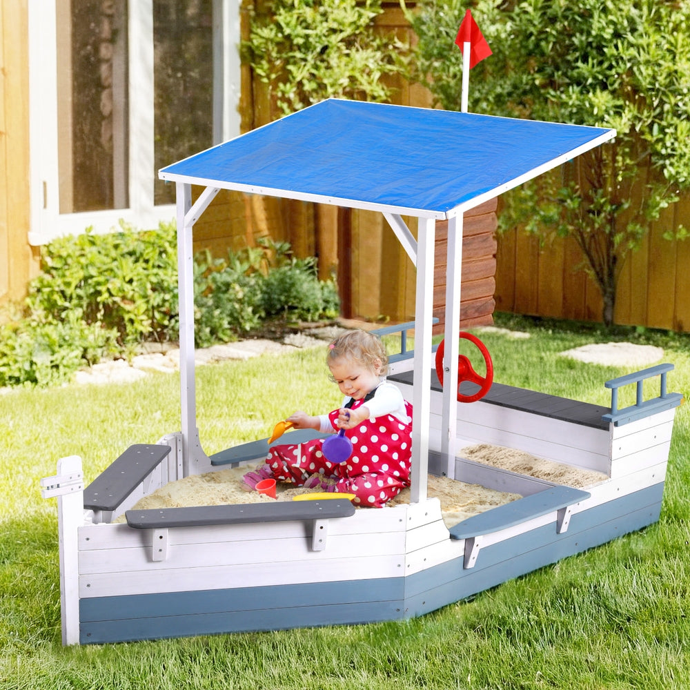 Wooden boat sandpit with canopy and flag in blue