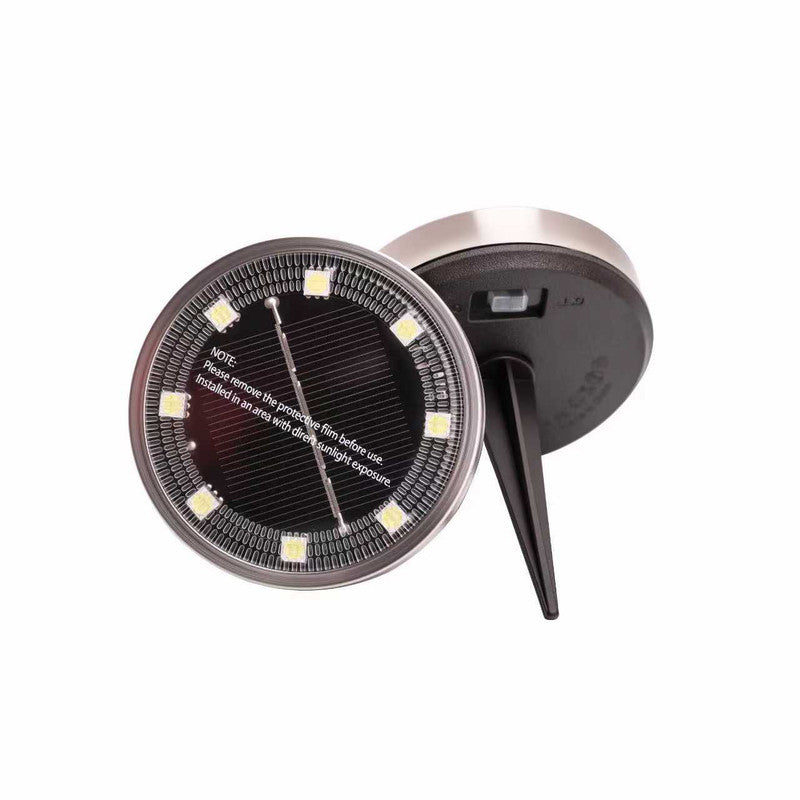 Solar garden spike light with warm white LEDs in a lawn