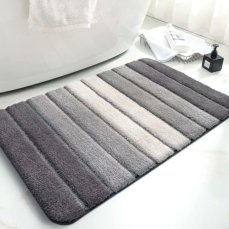 Grey microfibre bath mat on a tiled bathroom floor beside a shower