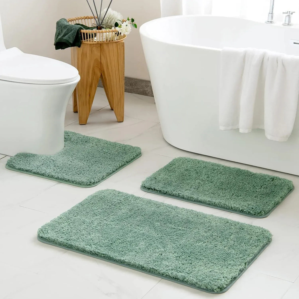 Sage green microfibre bathroom rug set of three pieces laid out on a tiled floor