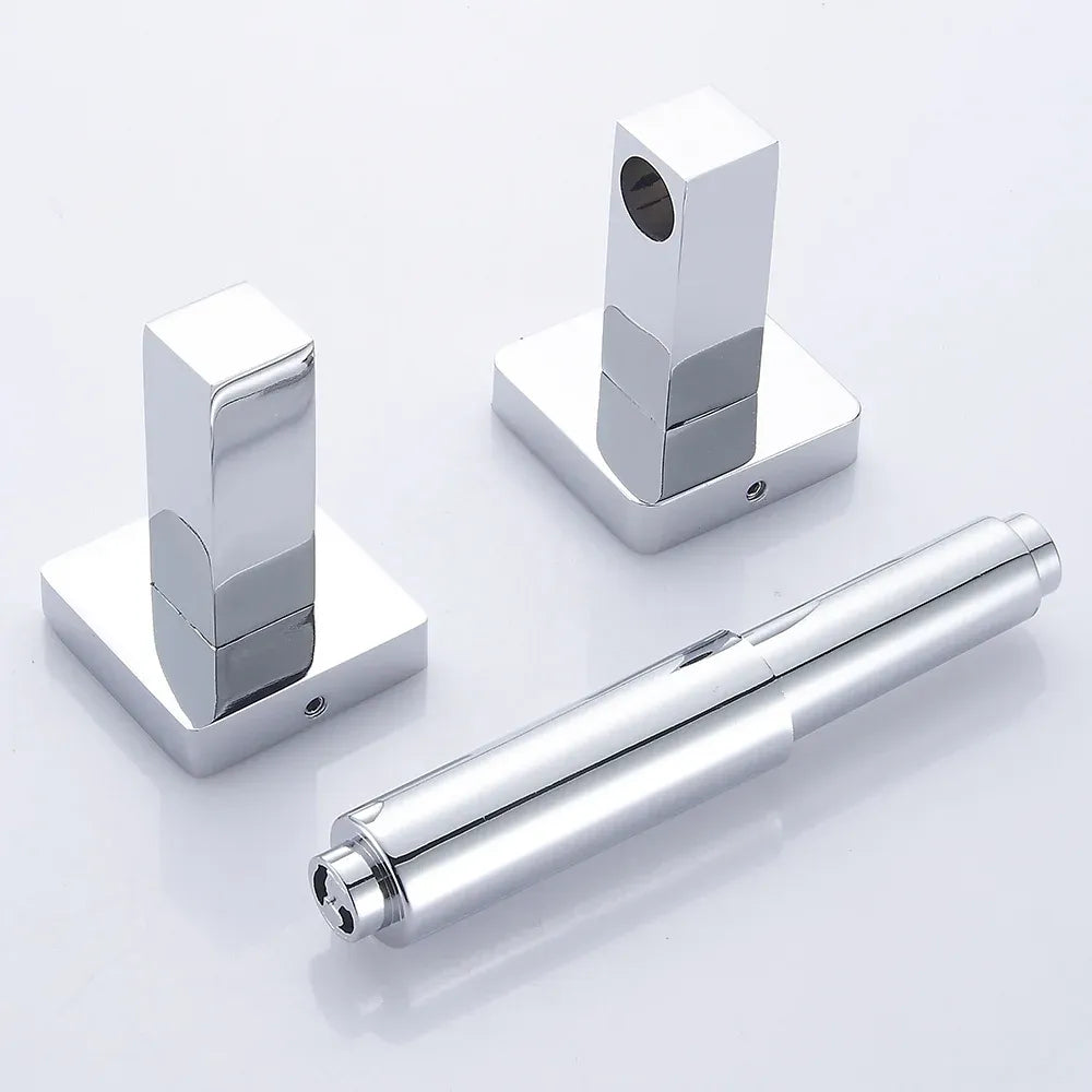 Chrome toilet paper holder mounted on a bathroom wall beside a toilet