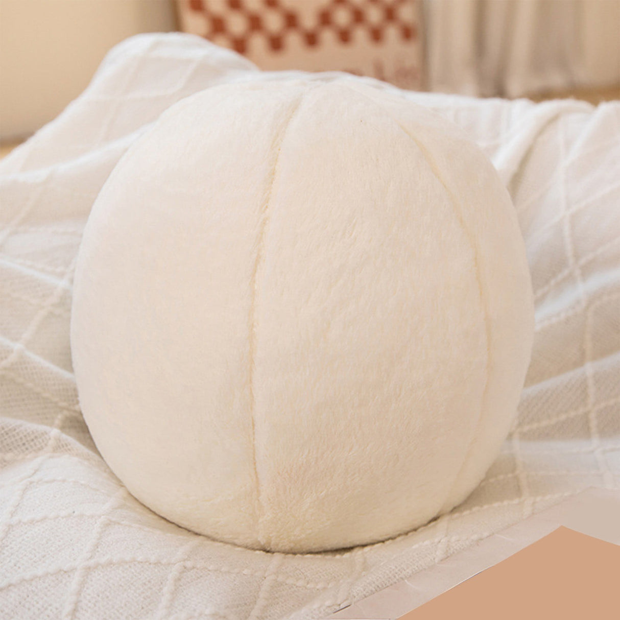Hayman white boucle round ball cushion on a sofa