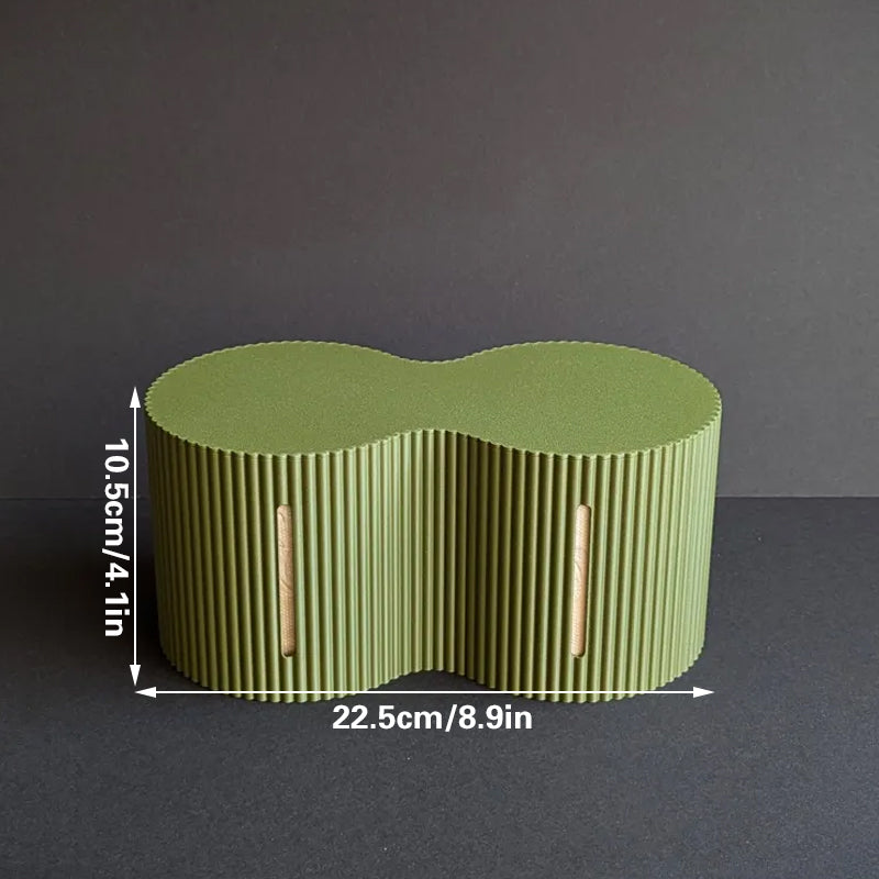 Light green roll storage box beside a toilet with spare rolls inside