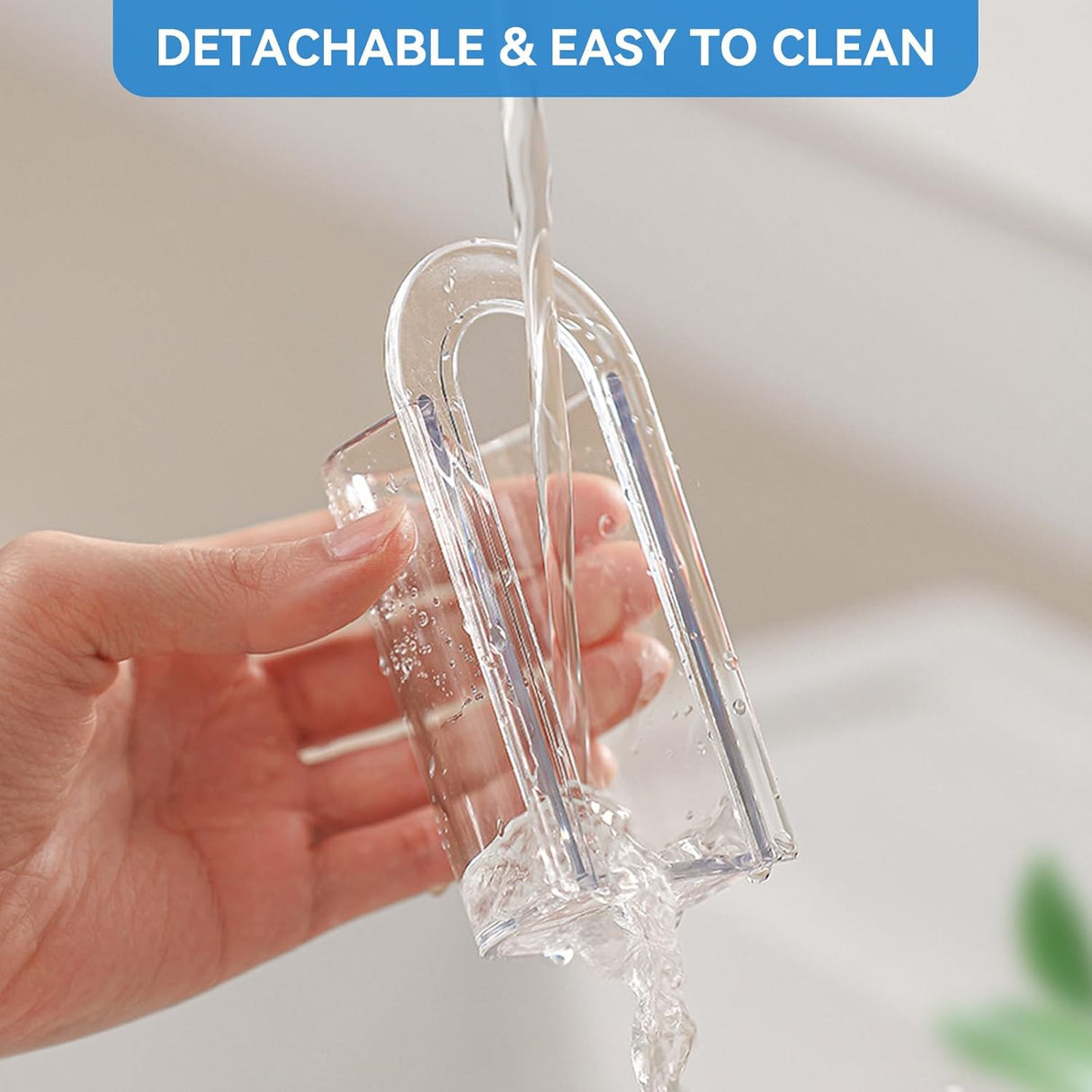 Clear toothbrush holder cylinder lifted off its adhesive base ready for rinsing