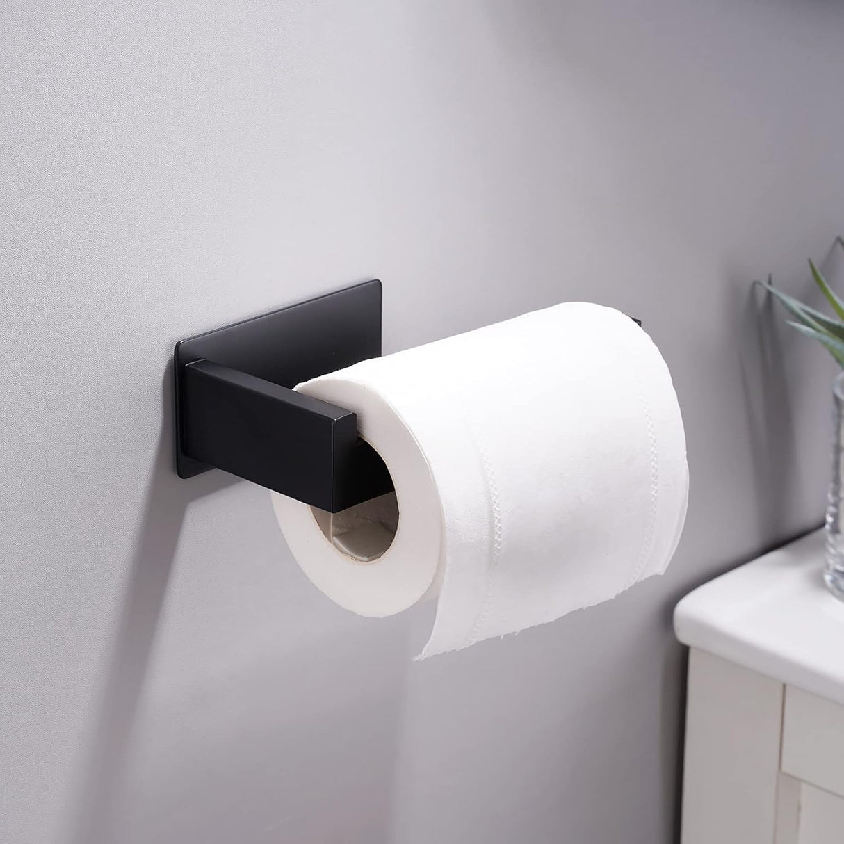 Side profile of the wall mounted black toilet roll holder showing its slim L shaped design