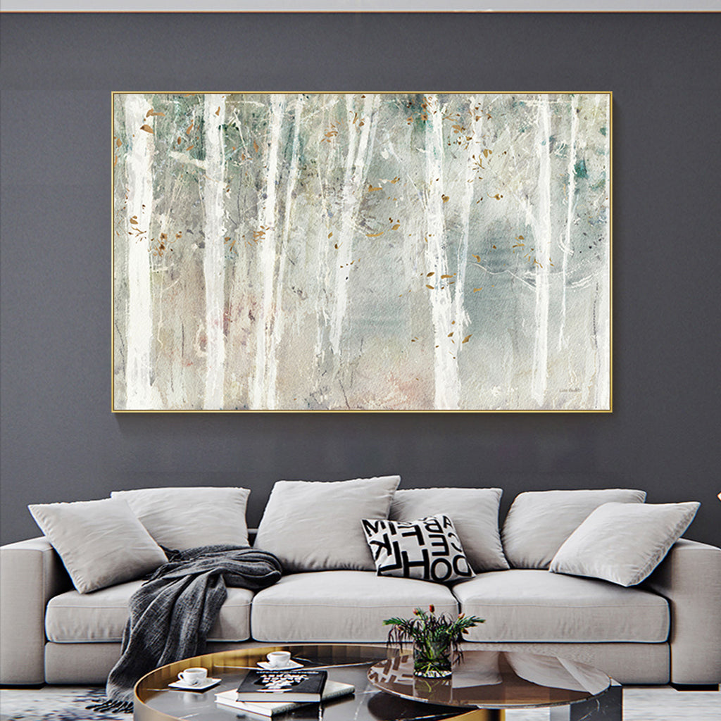 Gold framed forest canvas print styled on a neutral interior wall