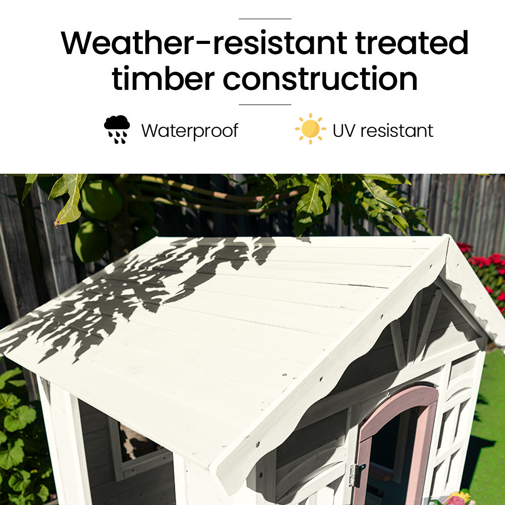 White wooden cubby house in a backyard