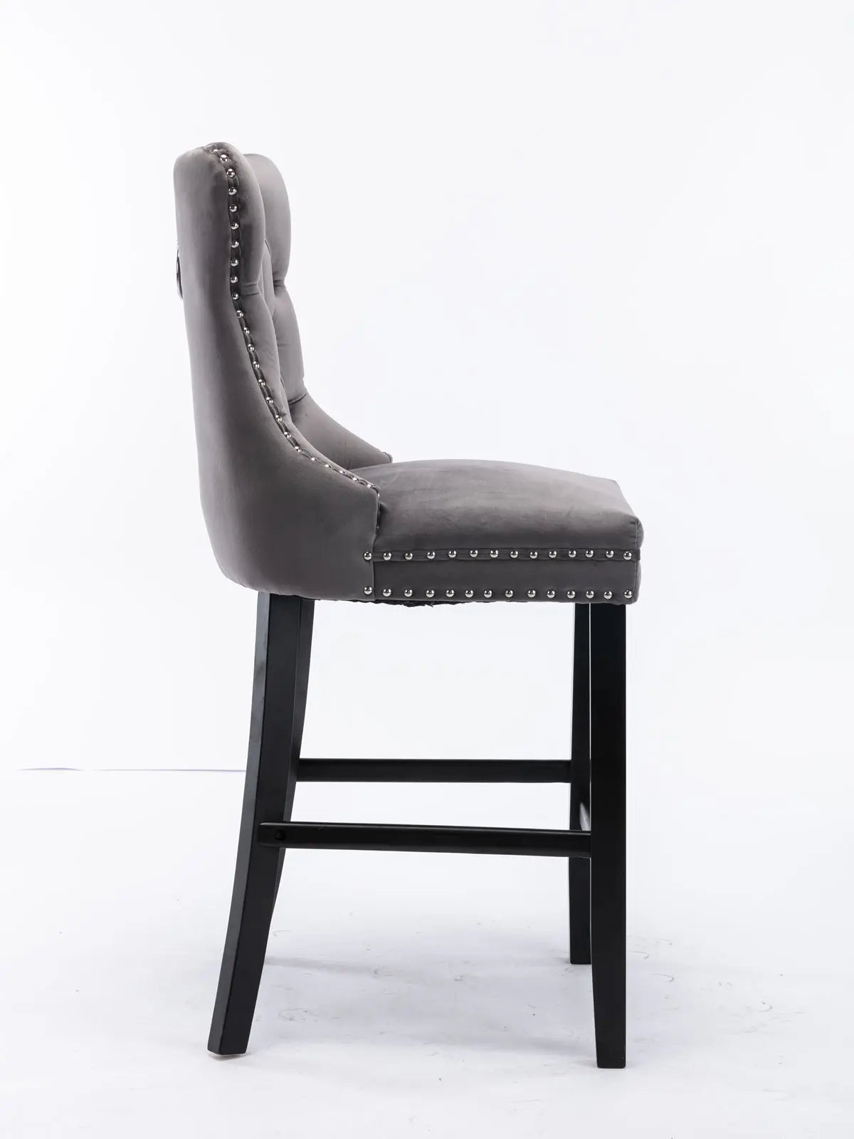 Waterways grey velvet bar stool with silver stud trim and wooden legs in a dining room