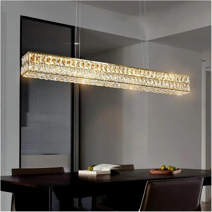 Linear gold crystal chandelier over a dining table