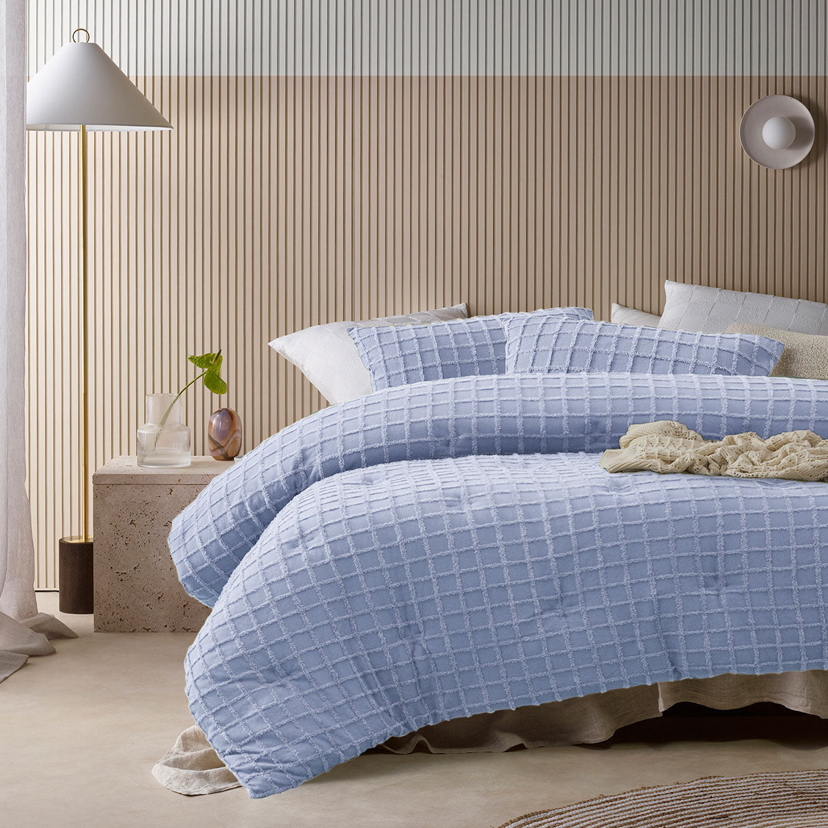 Blue comforter set with a geometric parquet print and two pillowcases on a queen bed