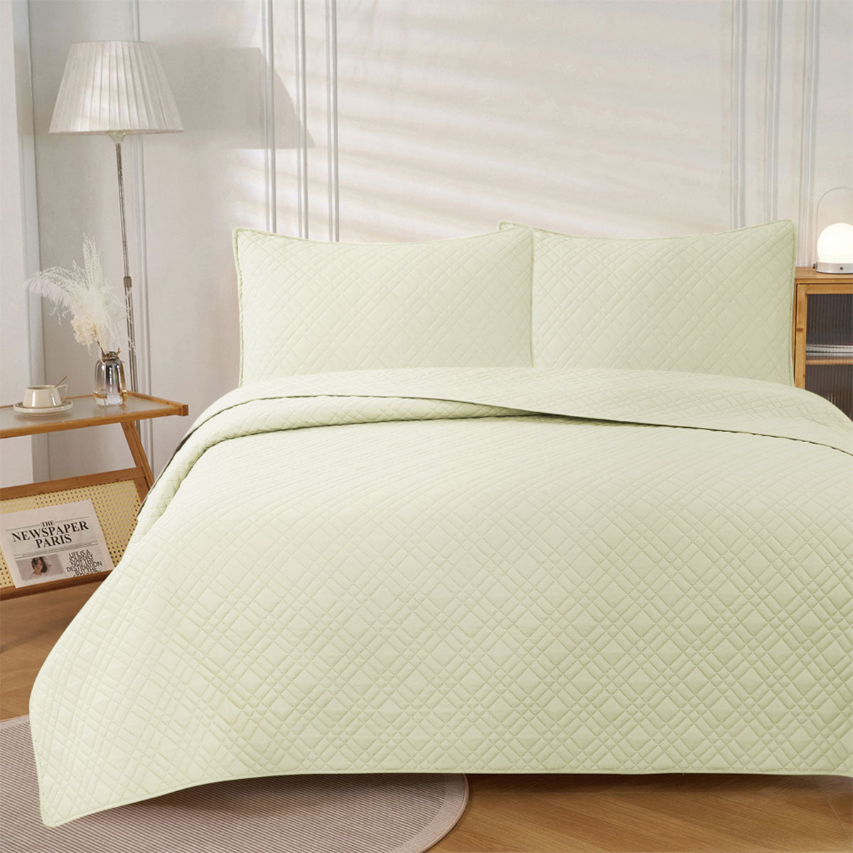 Light cream ultrasonic embossed reversible coverlet with two pillowcases on a King bed