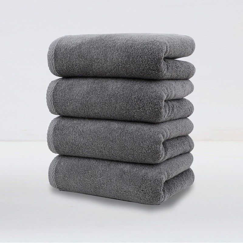 Set of 4 plush dark grey cotton hand towels, folded and stacked