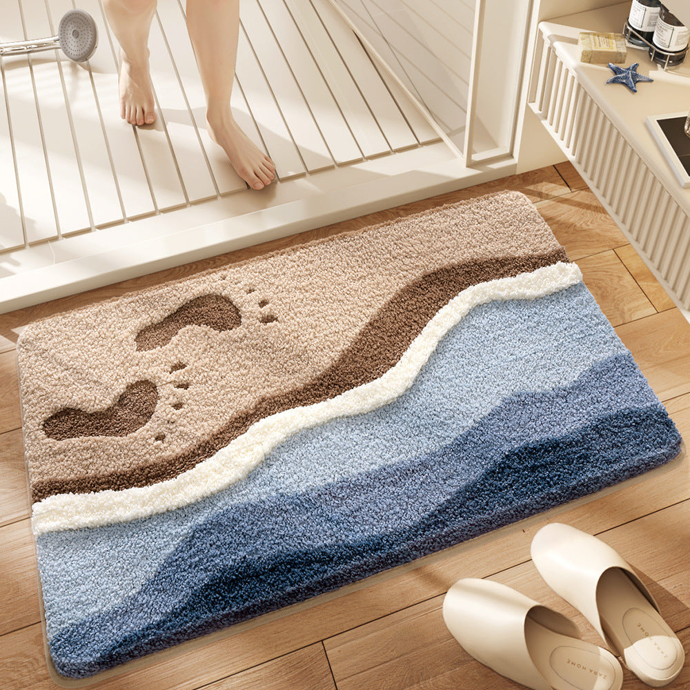 Plush quick dry bath mat with a seaside footprints print laid on a bathroom floor
