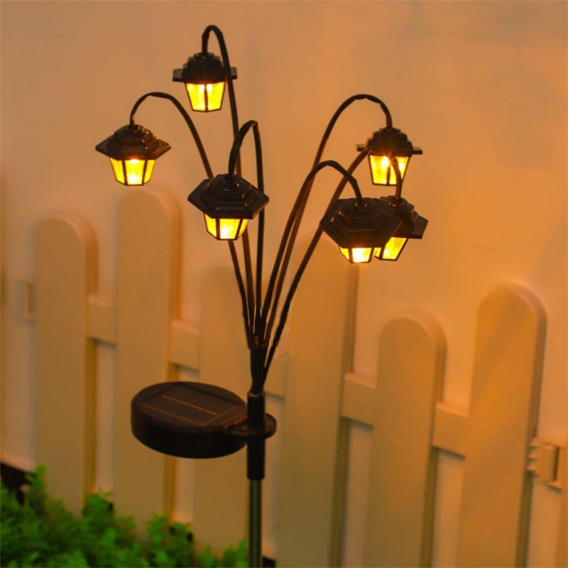Retro hexagonal solar stake light glowing warm white on a garden path
