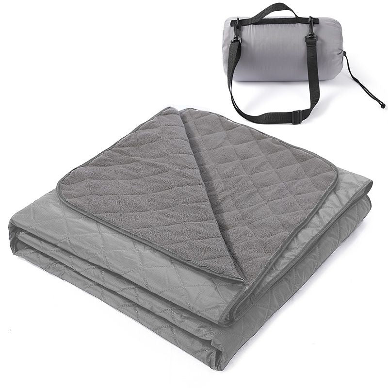 Grasmere double layer fleece picnic blanket in grey folded beside its zippered shoulder carry bag on grass