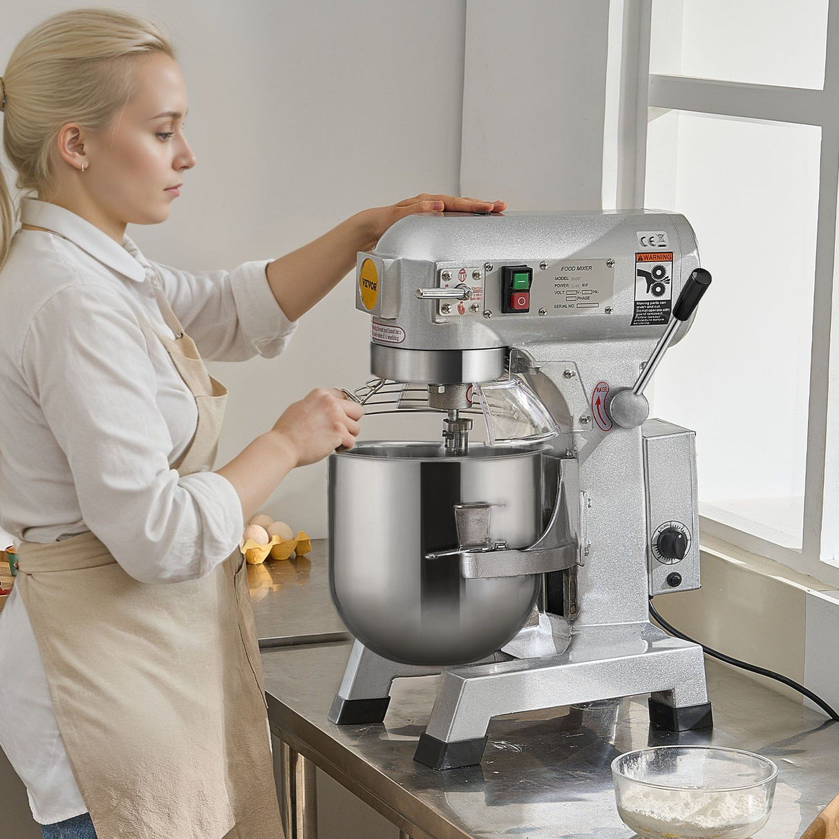Dough being kneaded by the hook in the stainless steel bowl