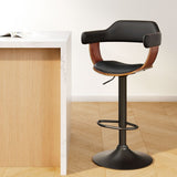 Dromana black faux leather swivel bar stool with armrests in a modern kitchen