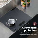 Grey cooktop in a modern kitchen with dark cabinetry