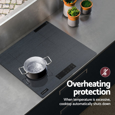 Grey cooktop in a modern kitchen with dark cabinetry
