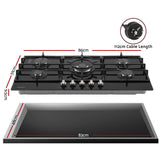 Black glass gas cooktop shown at an angle with cast iron pan supports