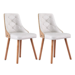 Houghton faux leather diamond tufted dining chairs in white or black in a dining room