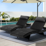 Black rattan wicker reclining sun lounger beside a pool