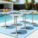 Modern silver outdoor bar setting with stools and table on a patio