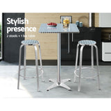 Black Rock silver aluminium 3 piece outdoor bar set with two stools and adjustable table on a patio