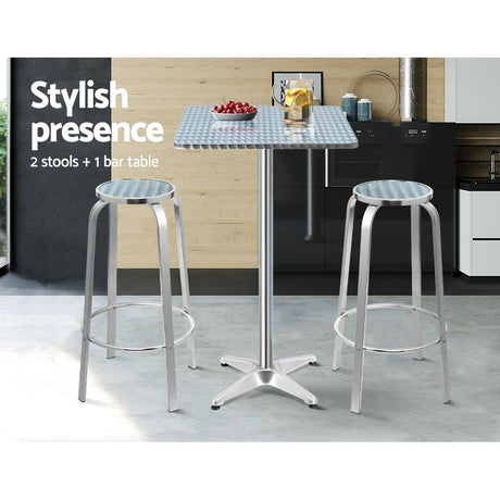 Black Rock silver aluminium 3 piece outdoor bar set with two stools and adjustable table on a patio