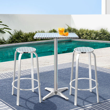 Black Rock silver aluminium 3 piece outdoor bar set with two stools and adjustable table on a patio