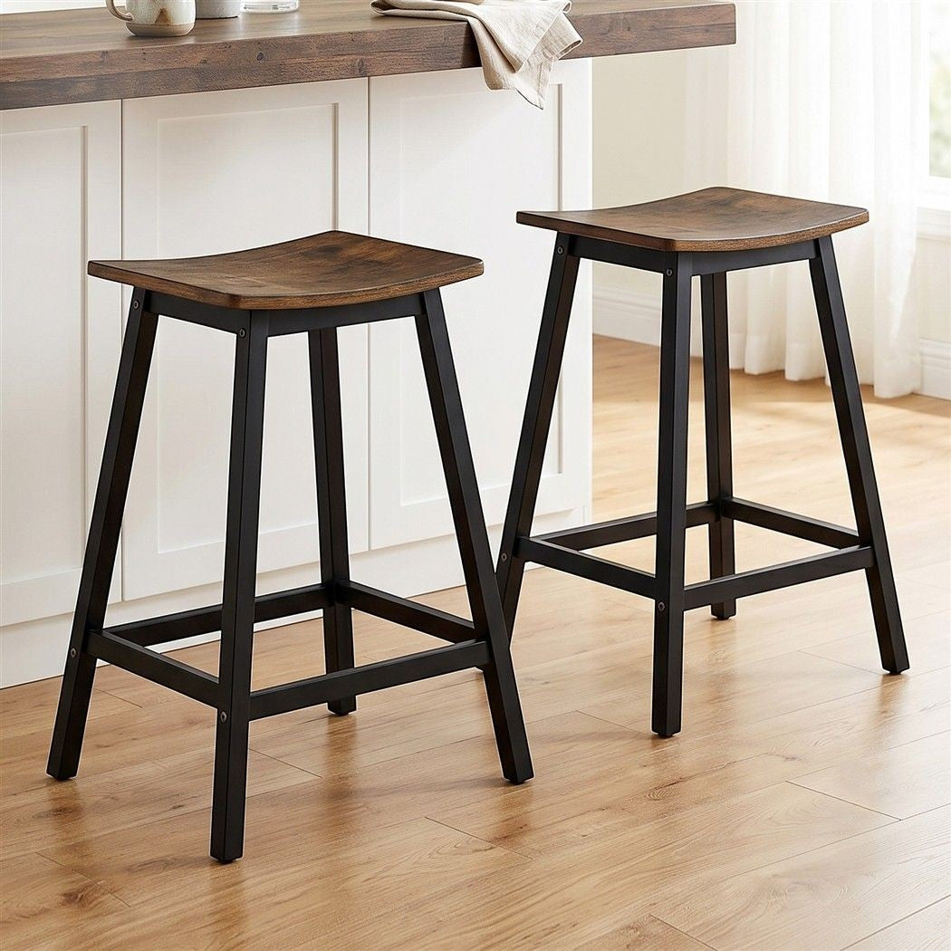Edithvale rustic brown wooden bar stool with saddle seat in an industrial kitchen