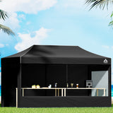 Black 3 x 6 m pop up gazebo erected outdoors with steel frame and long canopy