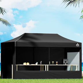 Black 3 x 6 m pop up gazebo erected outdoors with steel frame and long canopy