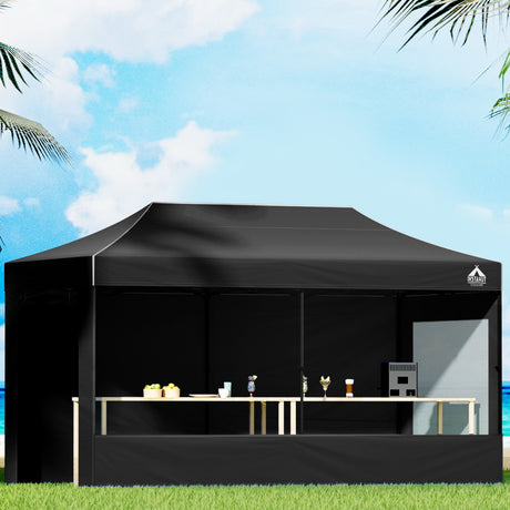 Black 3 x 6 m pop up gazebo erected outdoors with steel frame and long canopy
