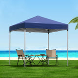 Blue 2 x 2 m pop up gazebo set up on grass in a backyard
