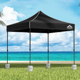 Black 3 x 3 m pop up gazebo with four base pods set up outdoors